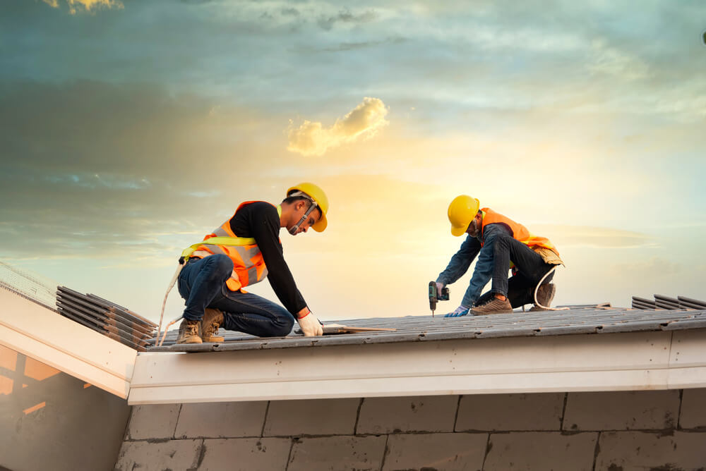 Asian engineer workers install new CPAC roof, roofing tools, electric drill, use on new roof with CPAC roof house construction idea.